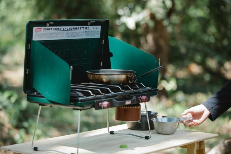 Crop unrecognizable male cooking on modern metal burner stove using skillet in forest – Food Planning